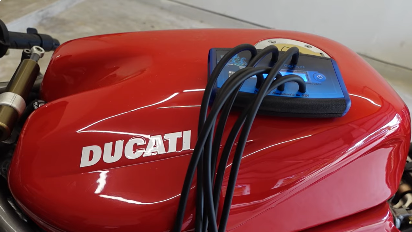 Digi Sync Digital Carb and Throttle Sync Tool laying on top of a Ducati 996